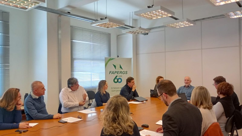 Sala de reuniões com os membros em volta da mesa